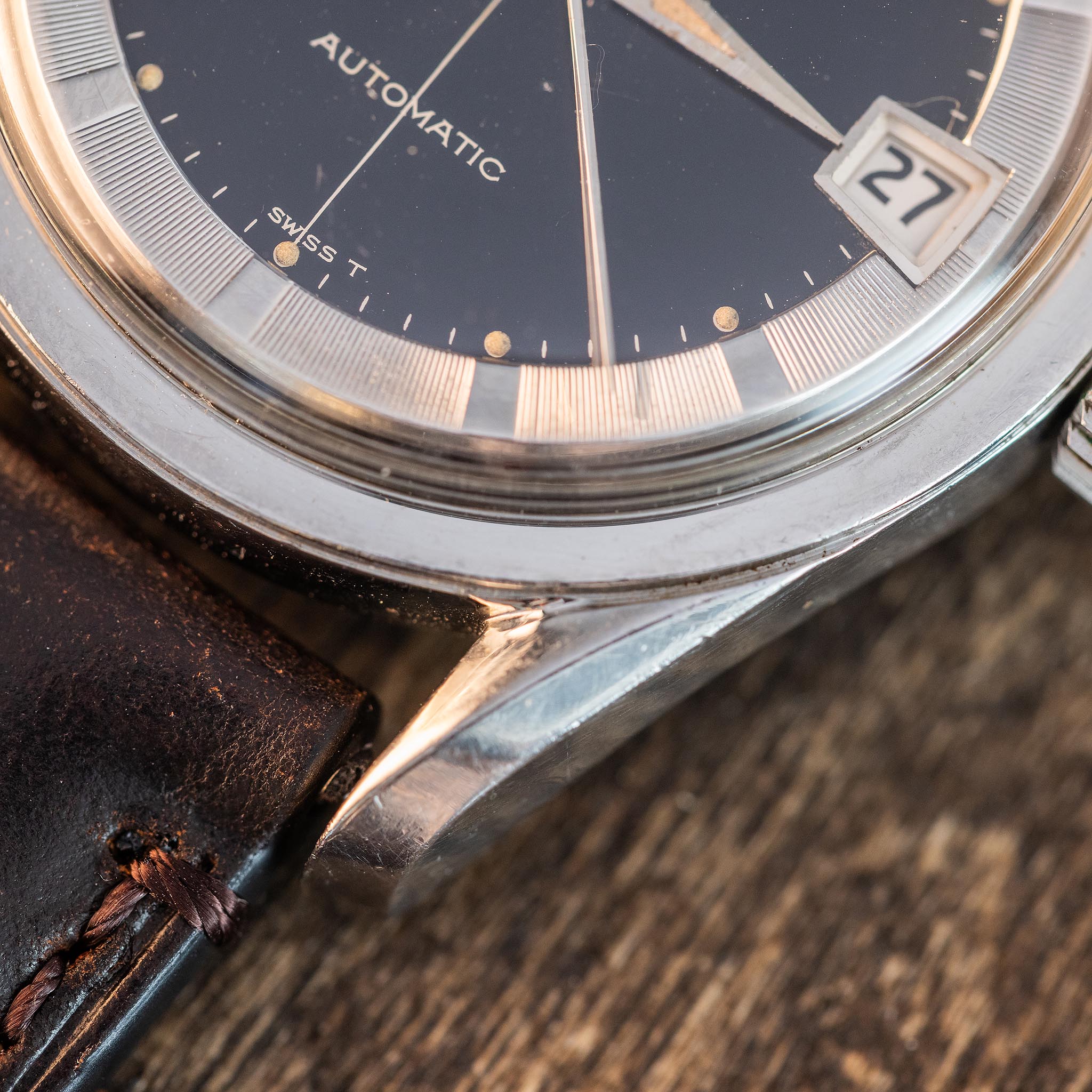 Close-up of the black crosshair dial and silver radial chapter ring of a Universal Genève Polerouter Date.