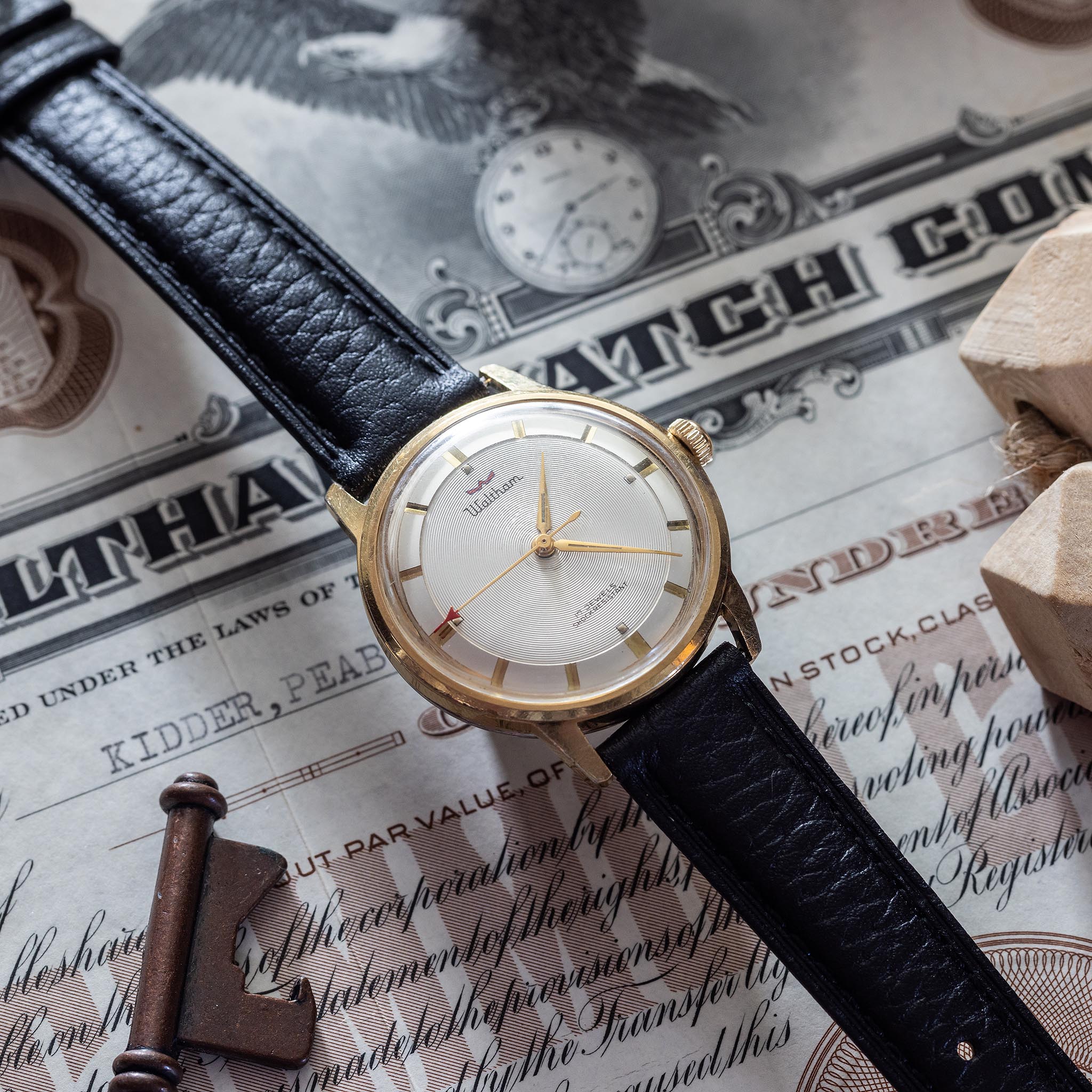Swiss-made Waltham 17-jewel wristwatch resting on an old Waltham Watch Company certificate.