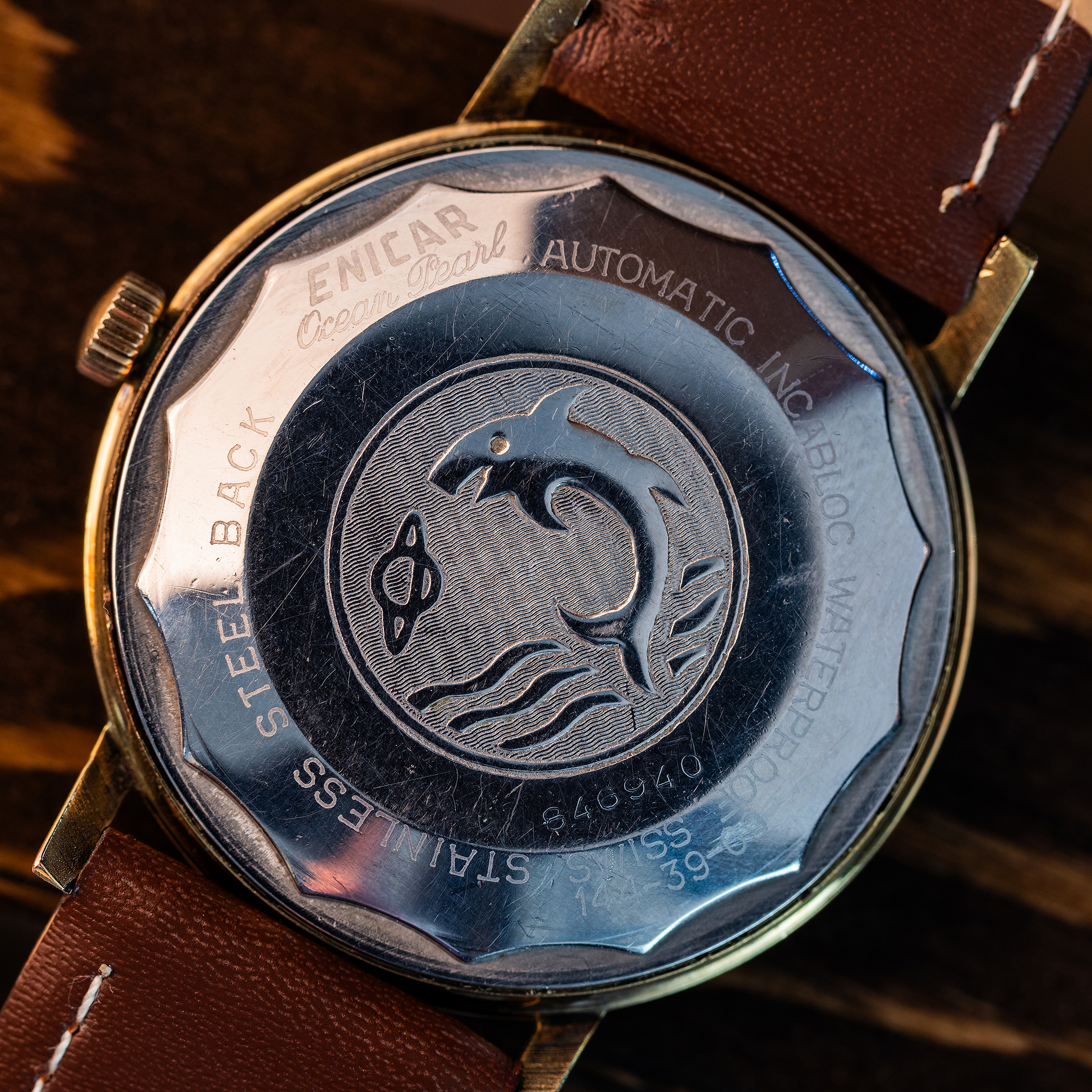 Exterior stainless-steel back of Enicar Ocean Pearl with detailed marine animal and Saturn medallion, Ocean Pearl and technical markings