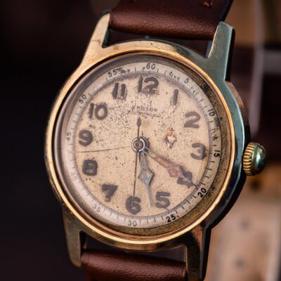 Vintage Croton wristwatch with a weathered, textured dial and a brown leather strap.