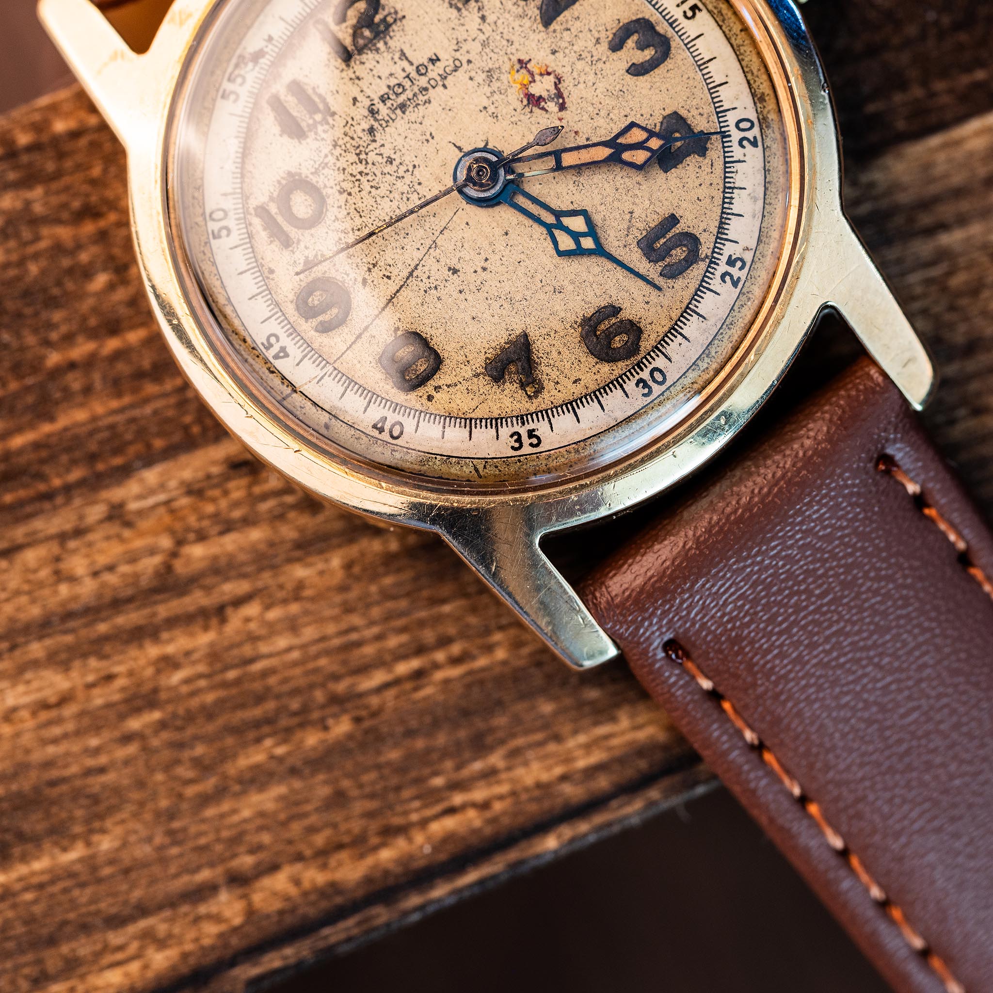 Croton Aquamedico face showing black skeletonized cathedral-style hour and minute hands over heavily patinated cream dial