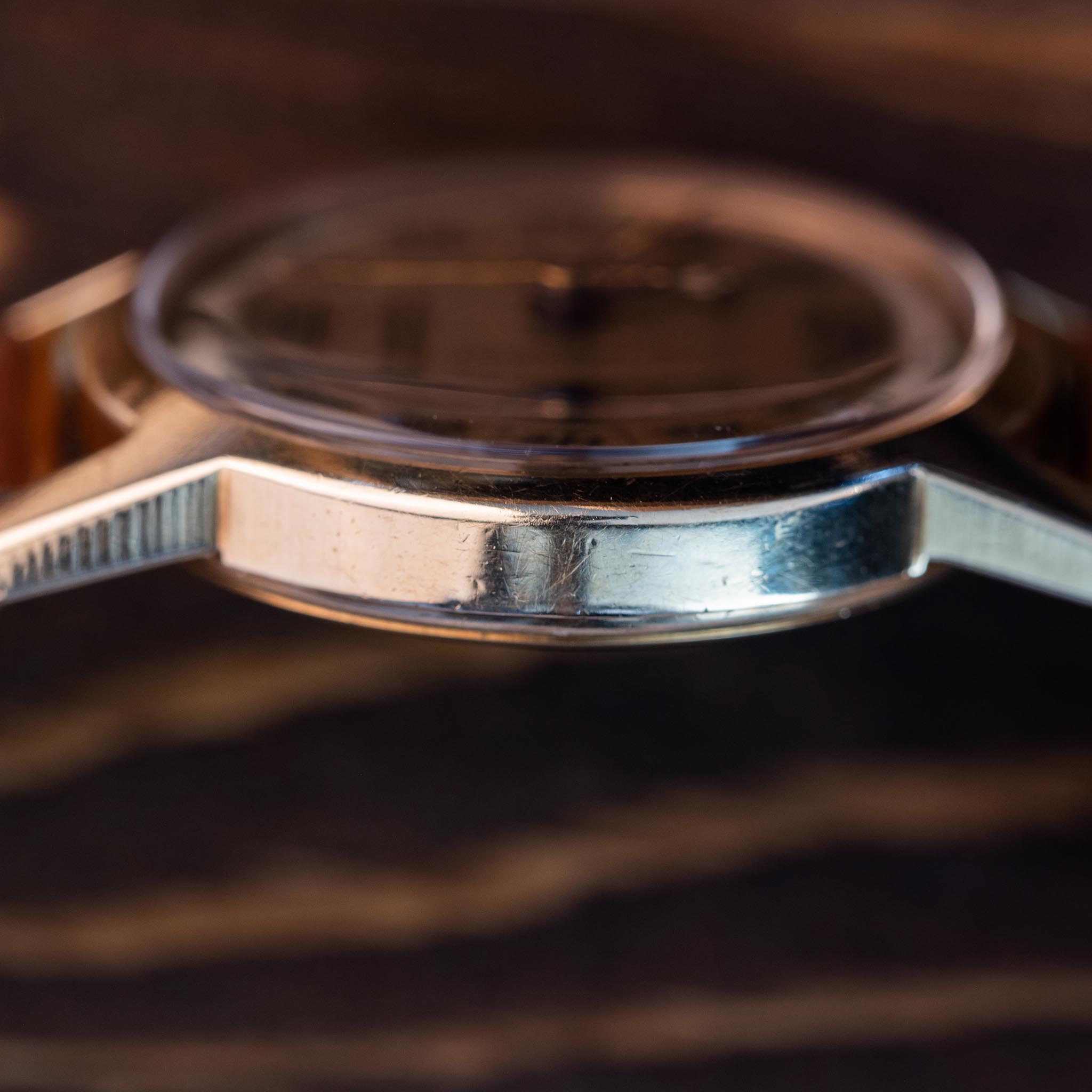 A close-up profile view of a vintage silver-toned Aquamedico wristwatch case.