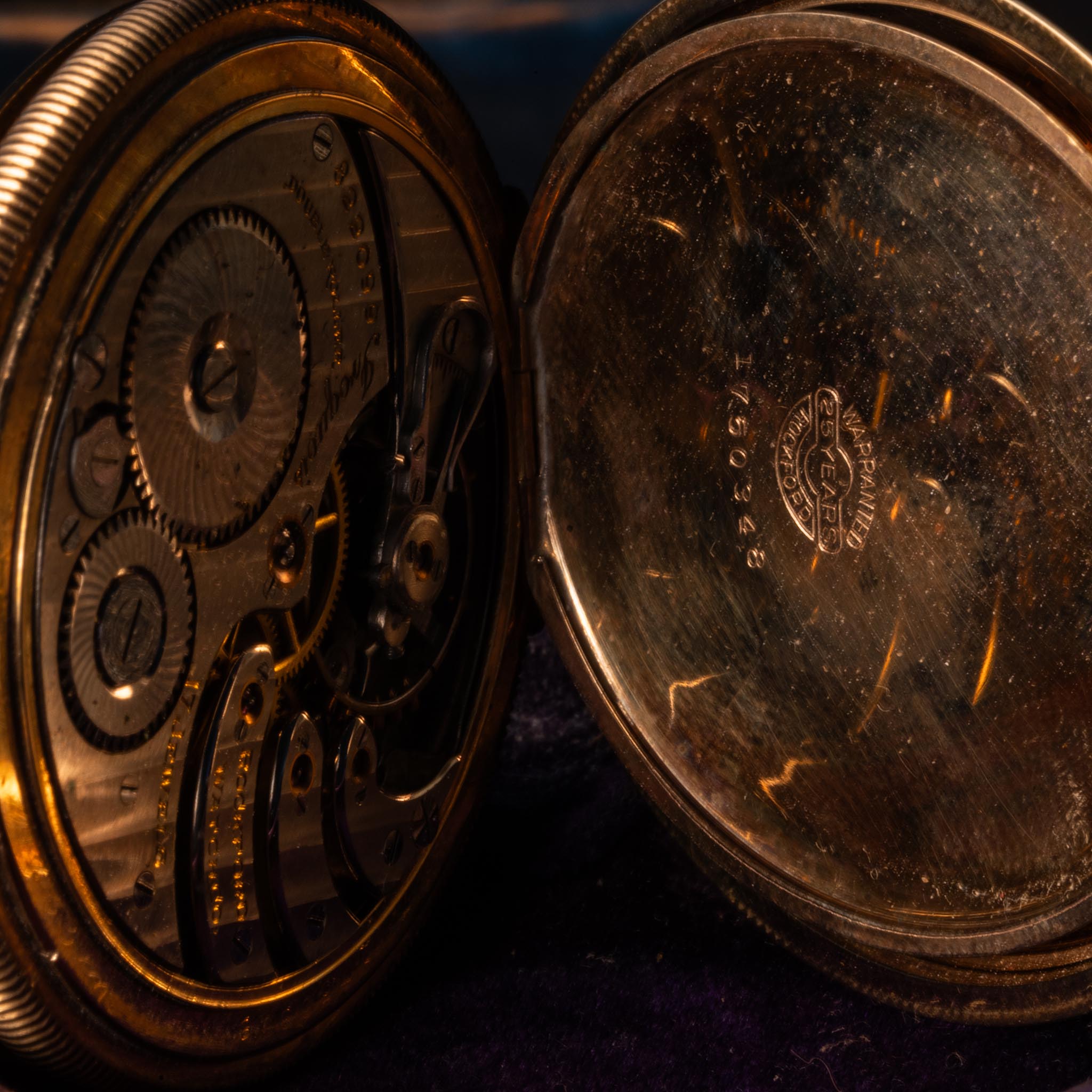 Close-up of a vintage Rockford Watch Co pocket watch with its cover open, revealing intricate inner gears on the left and engraved markings inside the shiny cover—perfect for collectors or resale.
